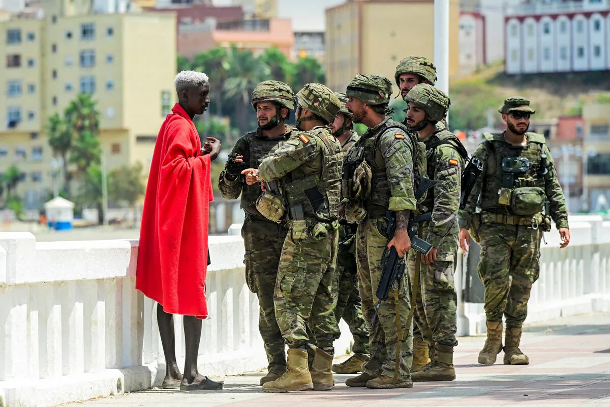 Испанские военнослужащие беседуют с мигрантом в Сеуте
